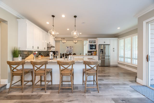a kitchen with white cabinets and granite counters